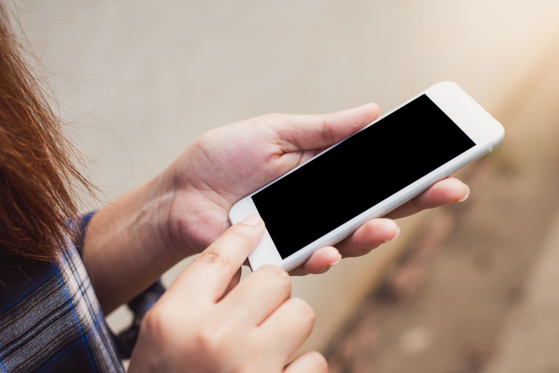 Person using a budgeting app UK on their smartphone at a kitchen table